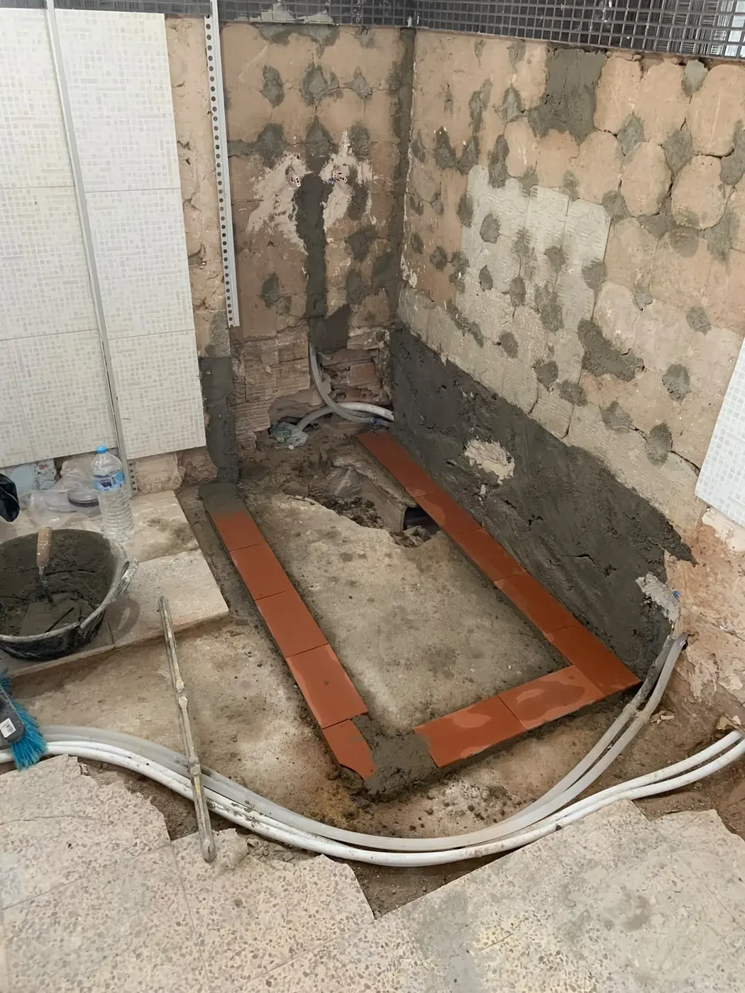 Baño en obra con alicatado antiguo picado