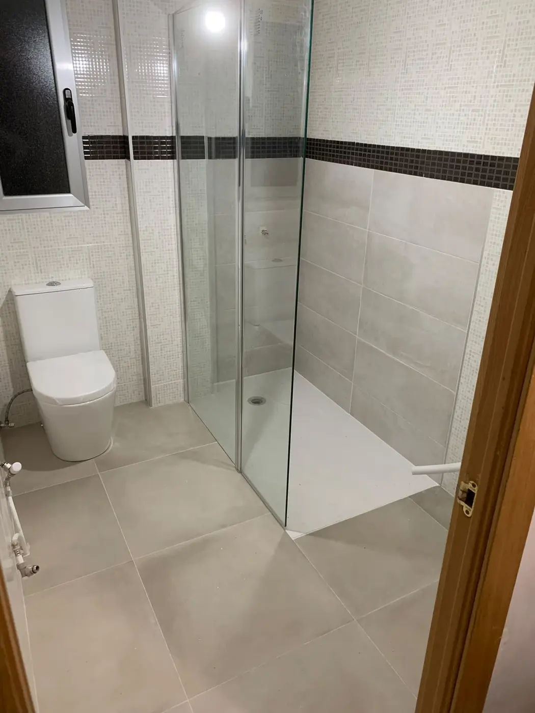 Ducha terminada con mampara de cristal y alicatado nuevo